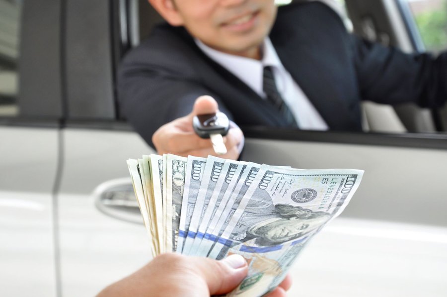 businessman-giving-a-car-key-exchanging-with-money-530950527-5aedf6e9875db90037597608